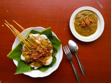 Sate Padang veya satay padang, Padang, Batı Sumatra 'dan baharatlı sığır eti satayıdır. Baharatlı köri sosu ve pirinç keki ile servis edilir, muz yaprağının üzerinde uzun süre. beyaz arkaplanda izole