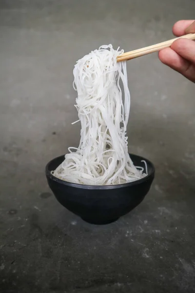 bihun or vermicelli or rice noodles or angel hair isolated on black background. served on small bowl