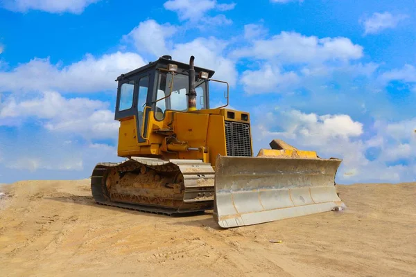 bulldozer with yellow color, on construction site and sky background