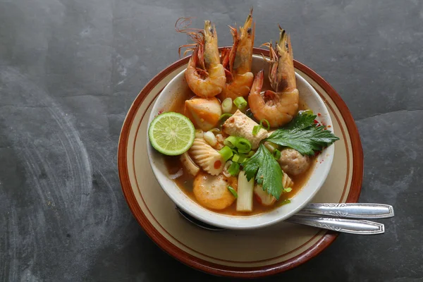 Tom yam soup originating from Thailand. Tom yum is made with shrimp, chili, lime, chicken, fish, or seafood and mushrooms.