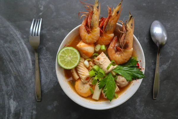 Tom yam soup originating from Thailand. Tom yum is made with shrimp, chili, lime, chicken, fish, or seafood and mushrooms.