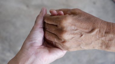 Yaşlıları nazikçe tutmak için el ele tutuşmanın görüntüsü