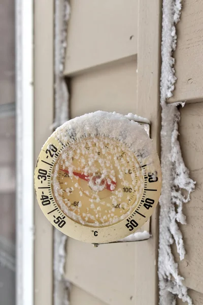 Frosty snow-capped outdoor Thermometer on a extremely cold, frigid winters day
