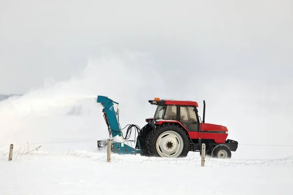 Trattore rosso neve soffiando un vialetto in un ambiente rurale — Foto Stock