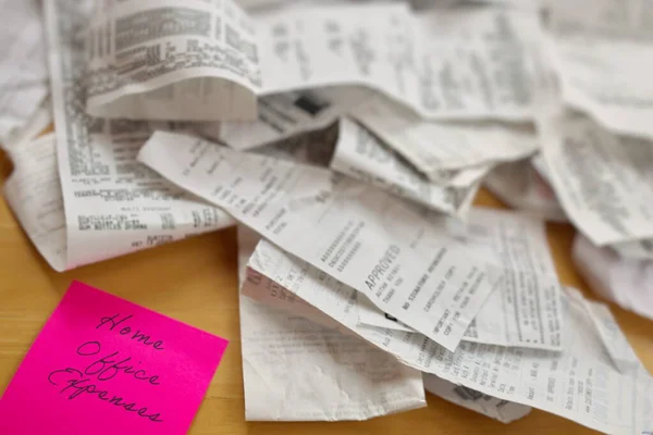 Hoge hoek uitzicht op stapel van ontvangstbewijzen met Home Office uitgaven Pink Sticky Note op tafel — Stockfoto