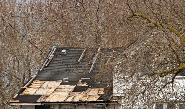 Residential Roof in Desperate Need of Repair or Replacement with Missing Shingles and Rotten Wood