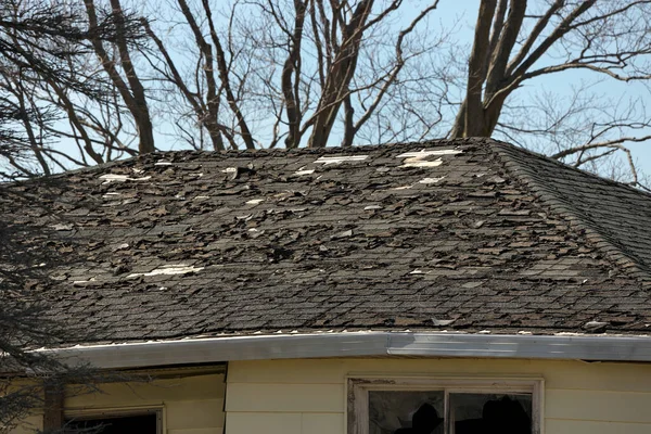 Residential Roof in Desperate Need of Repair or Replacement with Missing Shingles and Rotten Wood