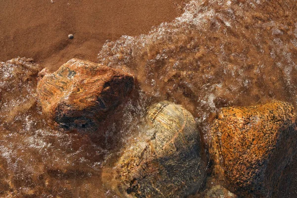 Renkli Kayalar ve Kayalar ile Noktalı Küçük Dalgalar Sahile Yuvarlanıyor