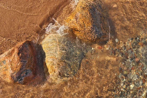 Renkli Kayalar ve Kayalar ile Noktalı Küçük Dalgalar Sahile Yuvarlanıyor
