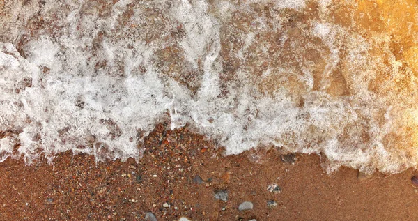 Directly Above full frame Close Up View Wave Surf Crashing into Beach Shore with Sunlight Gradient — Stockfoto