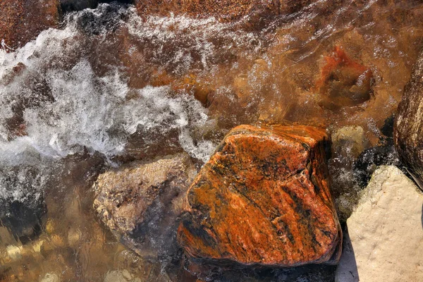 Renkli Kayalar ve Kayalar ile Noktalı Küçük Dalgalar Sahile Yuvarlanıyor