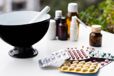 Alternatif tıp. Hap ve ilaç şişeleriyle havan topu ve tokmak