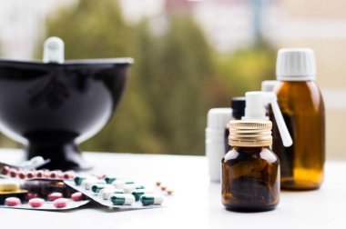 Alternatif tıp. Hap ve ilaç şişeleriyle havan topu ve tokmak