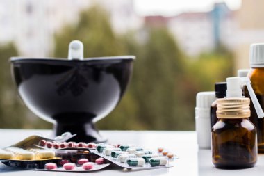 Alternatif tıp. Hap ve ilaç şişeleriyle havan topu ve tokmak