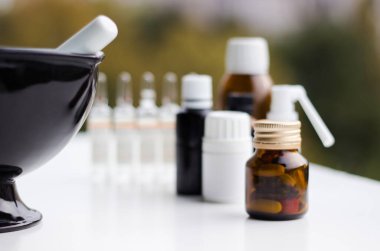 Alternatif tıp. Hap ve ilaç şişeleriyle havan topu ve tokmak