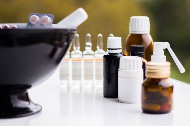 Alternatif tıp. Hap ve ilaç şişeleriyle havan topu ve tokmak