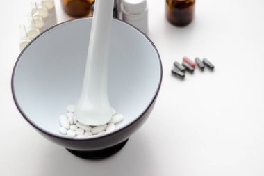 Alternatif tıp. Hap ve ilaç şişeleriyle havan topu ve tokmak