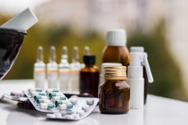 Alternatif tıp. Hap ve ilaç şişeleriyle havan topu ve tokmak