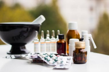 Alternatif tıp. Hap ve ilaç şişeleriyle havan topu ve tokmak