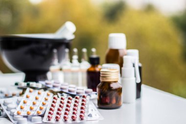 Alternatif tıp. Hap ve ilaç şişeleriyle havan topu ve tokmak