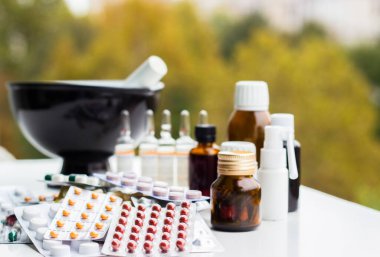 Alternatif tıp. Hap ve ilaç şişeleriyle havan topu ve tokmak