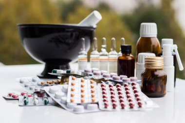 Alternatif tıp. Hap ve ilaç şişeleriyle havan topu ve tokmak