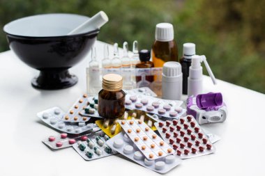 Alternatif tıp. Hap ve ilaç şişeleriyle havan topu ve tokmak