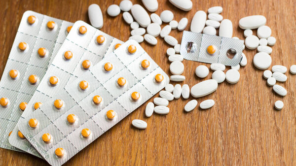 Medications and tablets on a wooden texture table