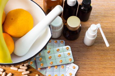 Geniş bir hap grubu, su toplayan paketler ve ilaç şişesi. Havan topu ve tokmak