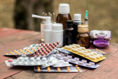 Ahşap masa üzerinde renkli haplar ve kapsüller, doğa zırvalıkları.