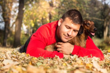 Genç bir adam köpeğiyle eğleniyor.