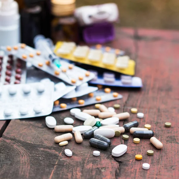Ahşap masa üzerinde renkli haplar ve kapsüller, doğa zırvalıkları.