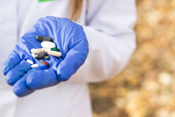 Pharmacist holding out handful of various Pills