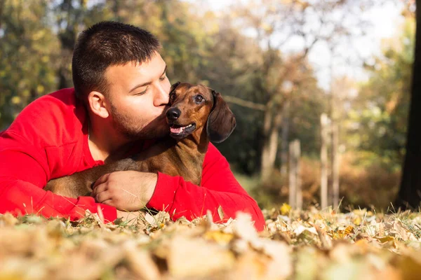 Genç bir adam köpeğiyle eğleniyor.