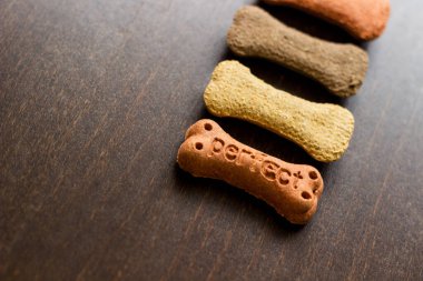 Köpek arkaplanda renkli bisküviler, köpekler için aperatifler. Sağlıklı kuru hayvan maması konsepti