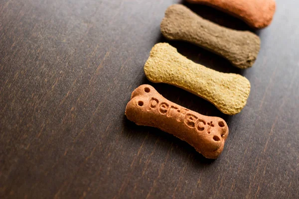 Köpek arkaplanda renkli bisküviler, köpekler için aperatifler. Sağlıklı kuru hayvan maması konsepti