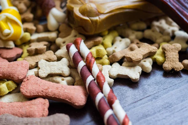 Pet food, snacks for dogs. Dog tasty colored biscuits on wooden background