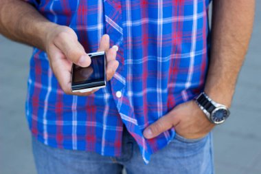 Cep telefonu kullanan genç bir adama yaklaş.