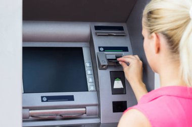Güzel bir iş kadını ATM 'den para alıyor.