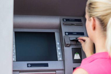 Güzel bir iş kadını ATM 'den para alıyor.