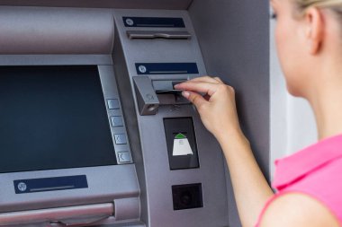 Güzel bir iş kadını ATM 'den para alıyor.