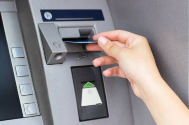Kadının eli kredi kartını ATM 'ye koyup kapatıyor.