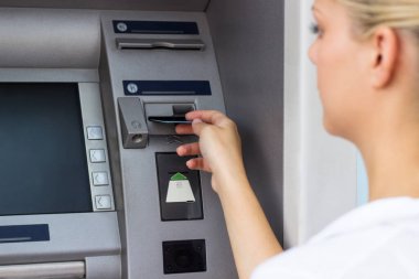 Güzel bir iş kadını ATM 'den para alıyor.