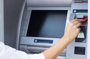 Kadının eli kredi kartını ATM 'ye koyup kapatıyor.