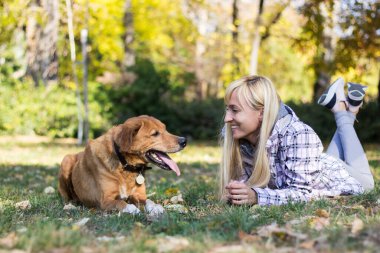 Olumlu genç kadın köpeğiyle mutlu anların tadını çıkarıyor.