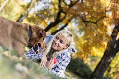 Olumlu genç kadın köpeğiyle mutlu anların tadını çıkarıyor.
