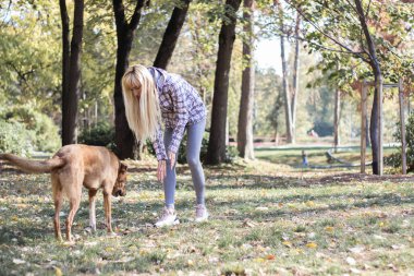 Olumlu genç kadın köpeğiyle mutlu anların tadını çıkarıyor.