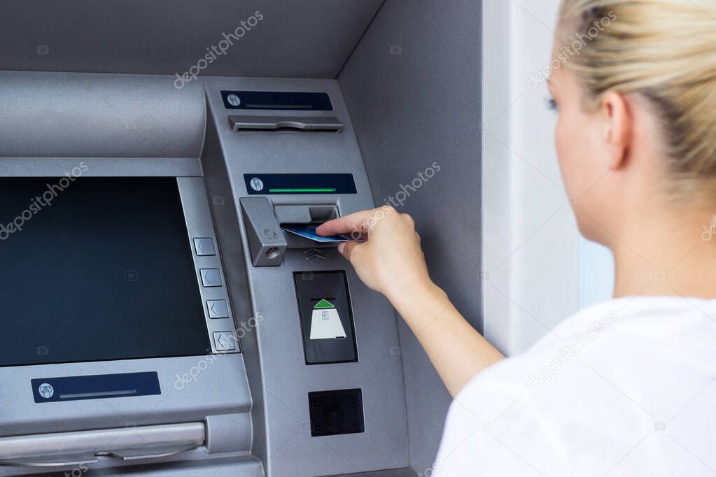 Beautiful businesswoman taking money from a ATM