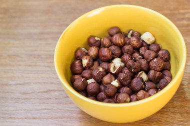 Ahşap masa üzerinde bir kase fındık