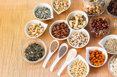 Ahşap arka planda karışık fındık ve hasır sepet çeşitleri